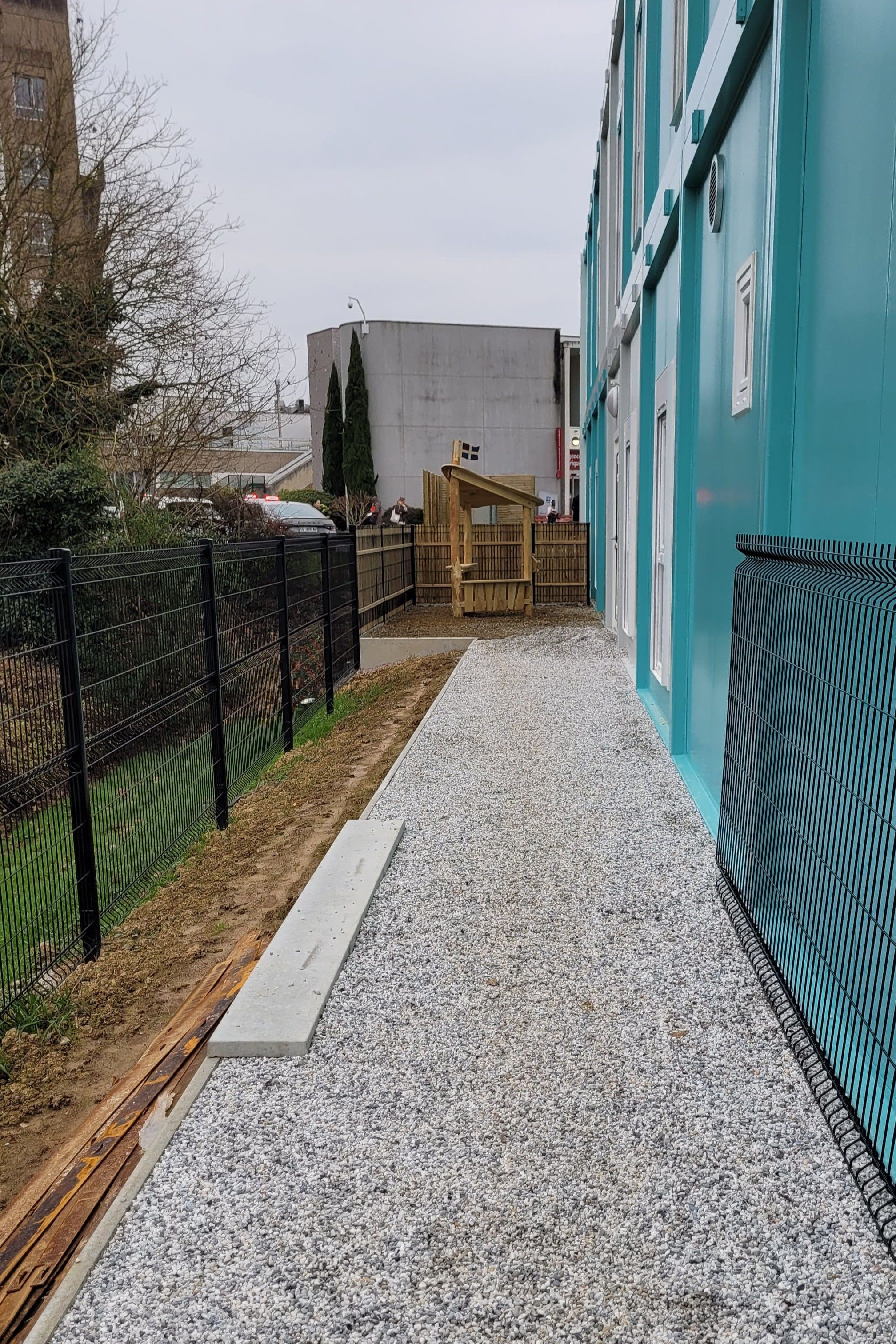 Entrée du bâtiment aménagée avec allée en nidagravel