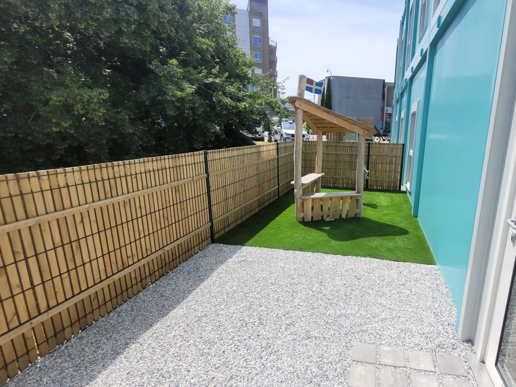 Pavés en joints graviers devant une porte menant à l’espace de jeux