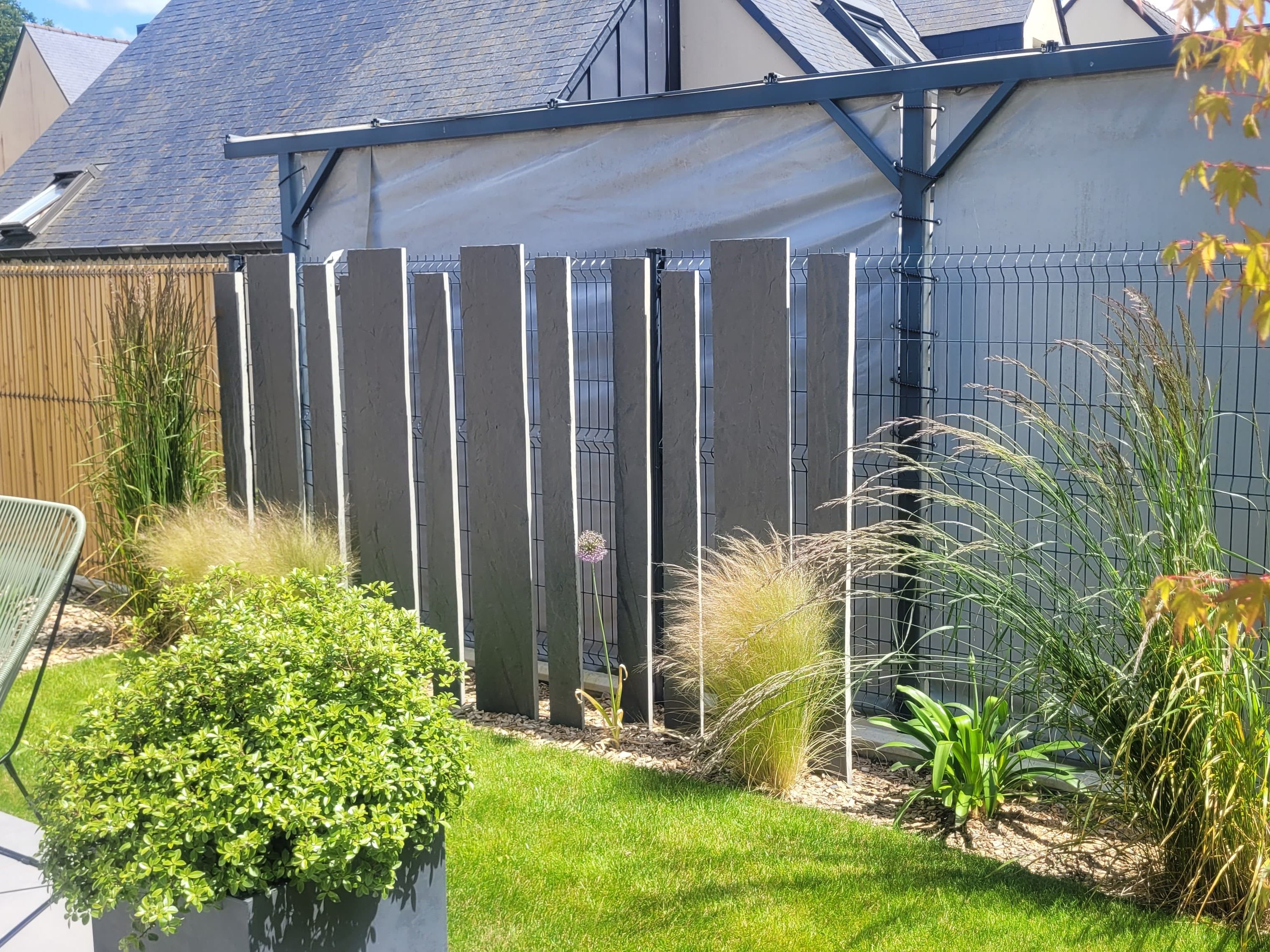 Décorations verticales en ardoise devant la clôture moderne.