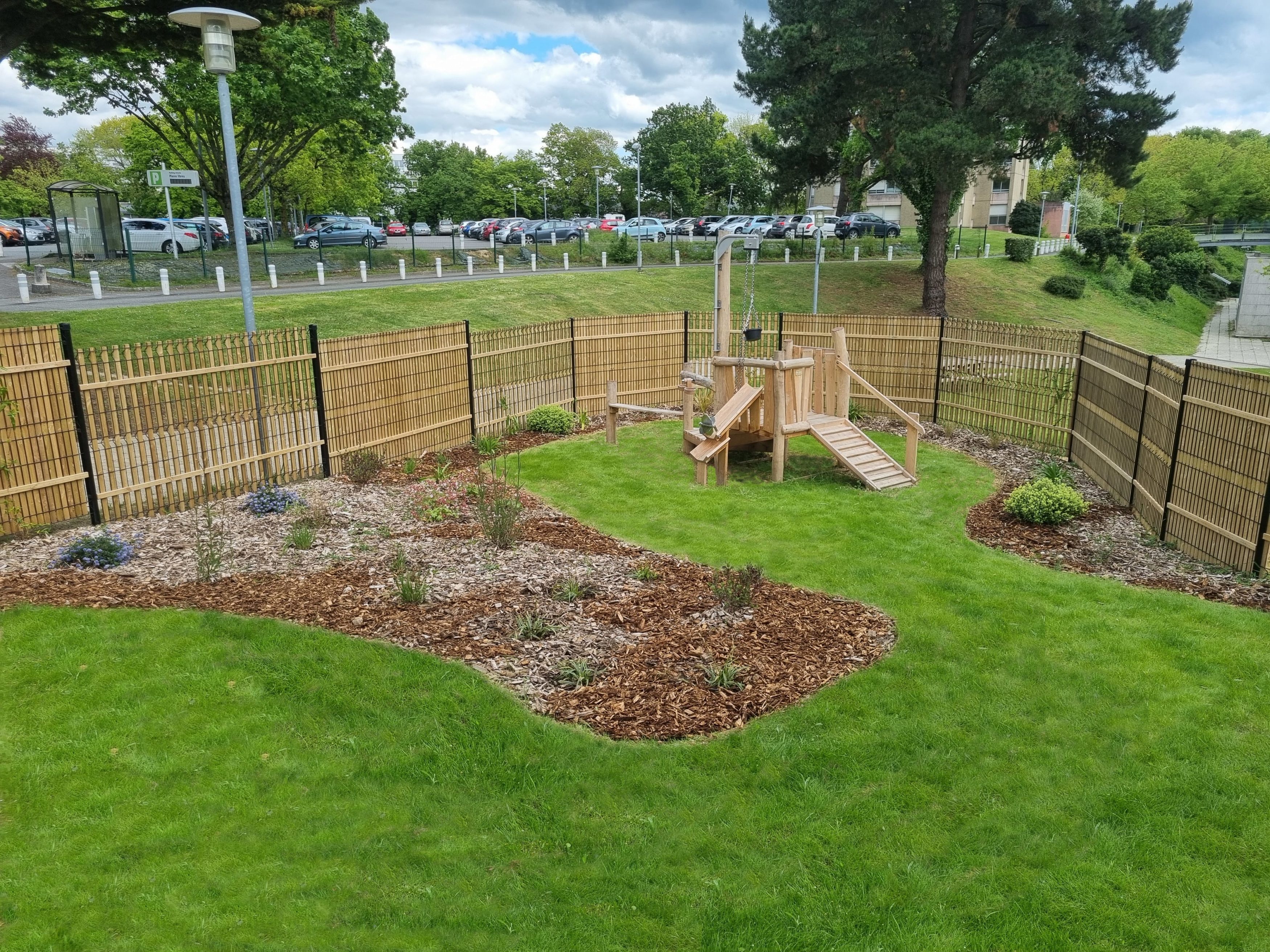 Végétation naturelle et jeu en bois dans un jardin paysager à Rennes