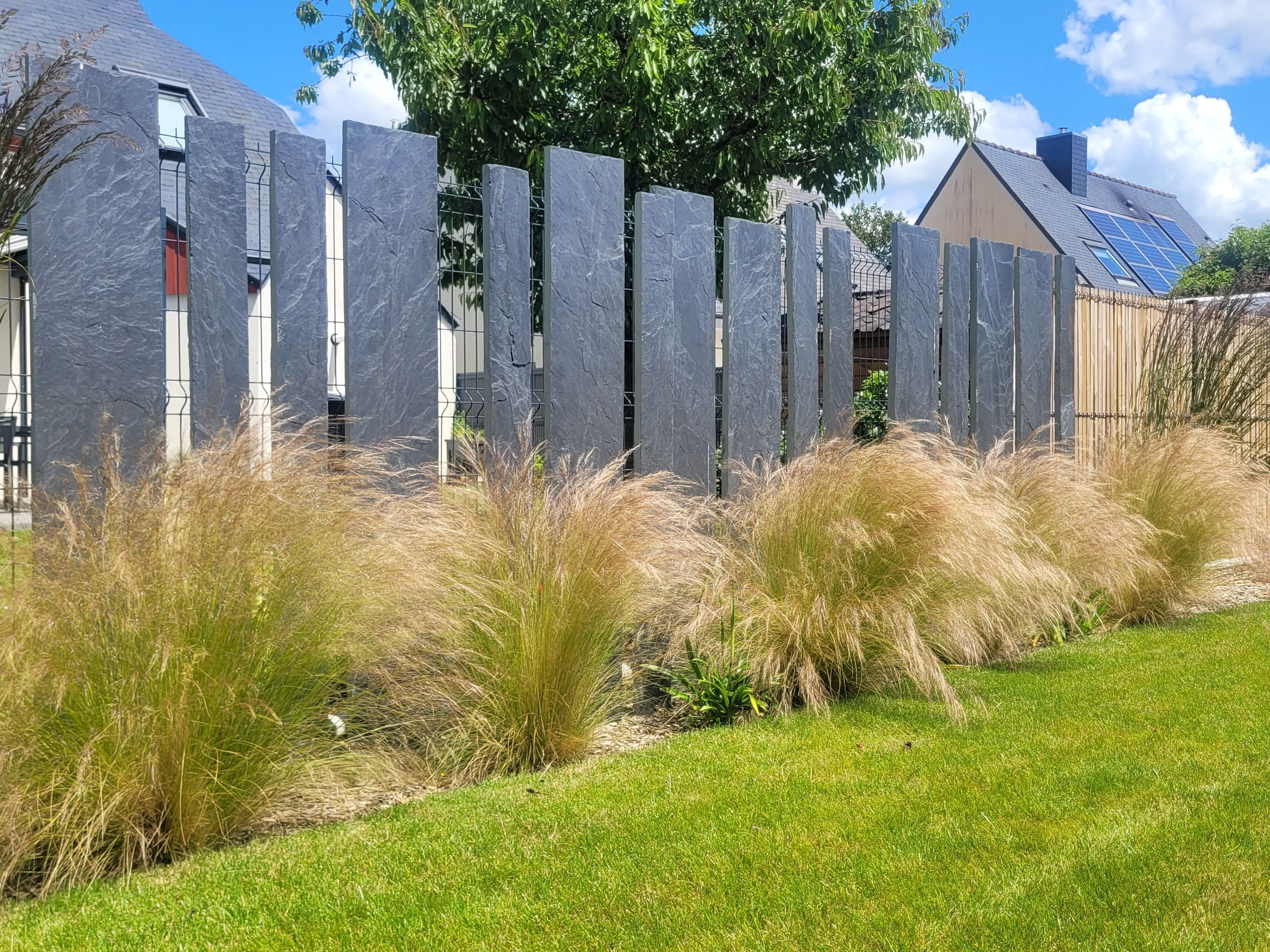 Décorations verticales en ardoise devant la clôture moderne.