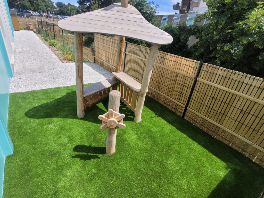 Gazon synthétique sous le jeu en bois pour plus d’amorti