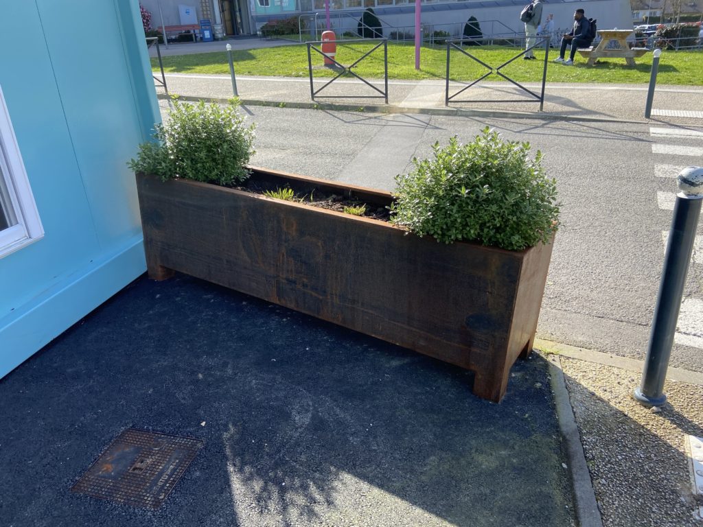 Jardinière en corten placée en façade du bâtiment