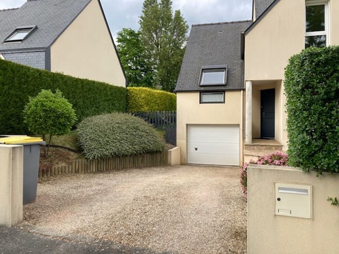 Vue extérieure d’une maison surélevée avec aménagement paysager complet.