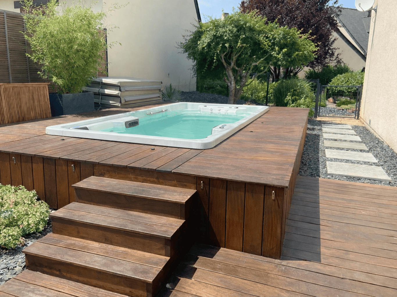 spa de nage surélevé avec habillage et escaliers en bois exotique