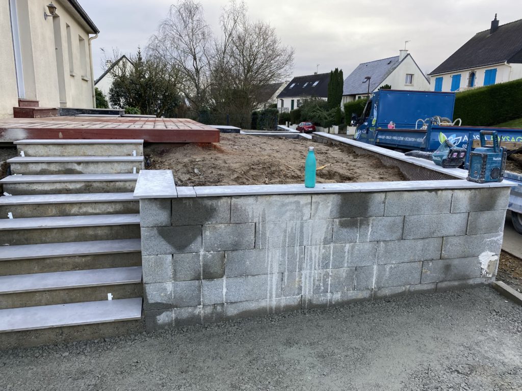 Réalisation d’un mur de soutènement en parpaings pour aménager les niveaux du terrain.