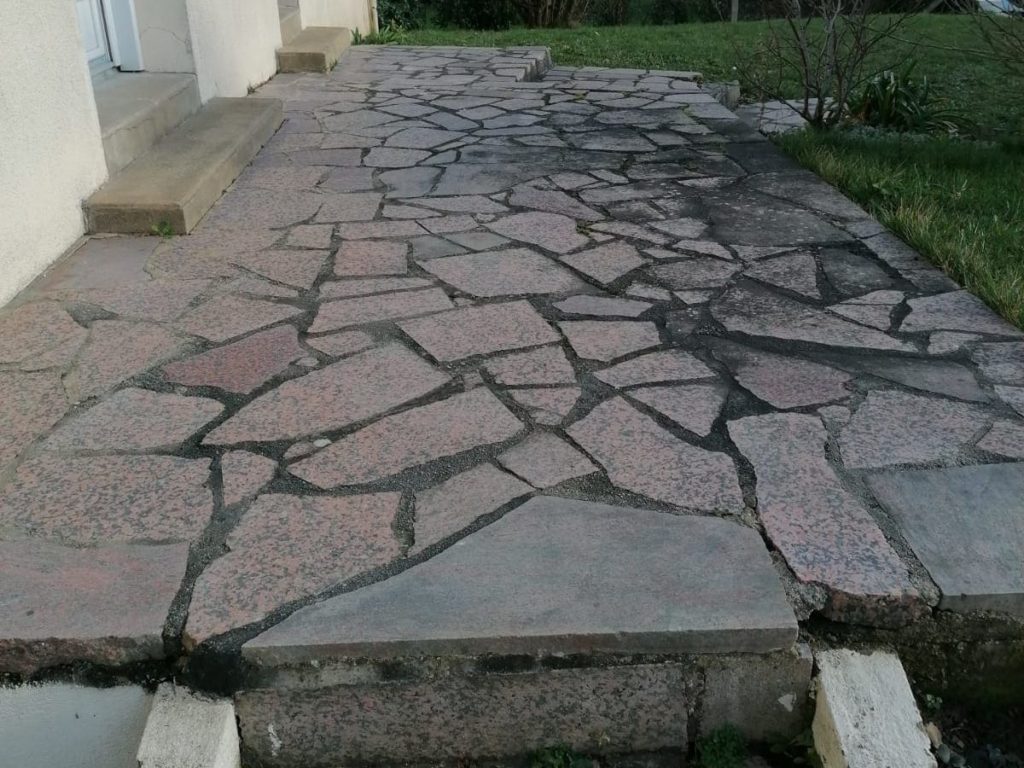 Ancienne terrasse en pierre avant son remplacement par une terrasse en bois exotique.