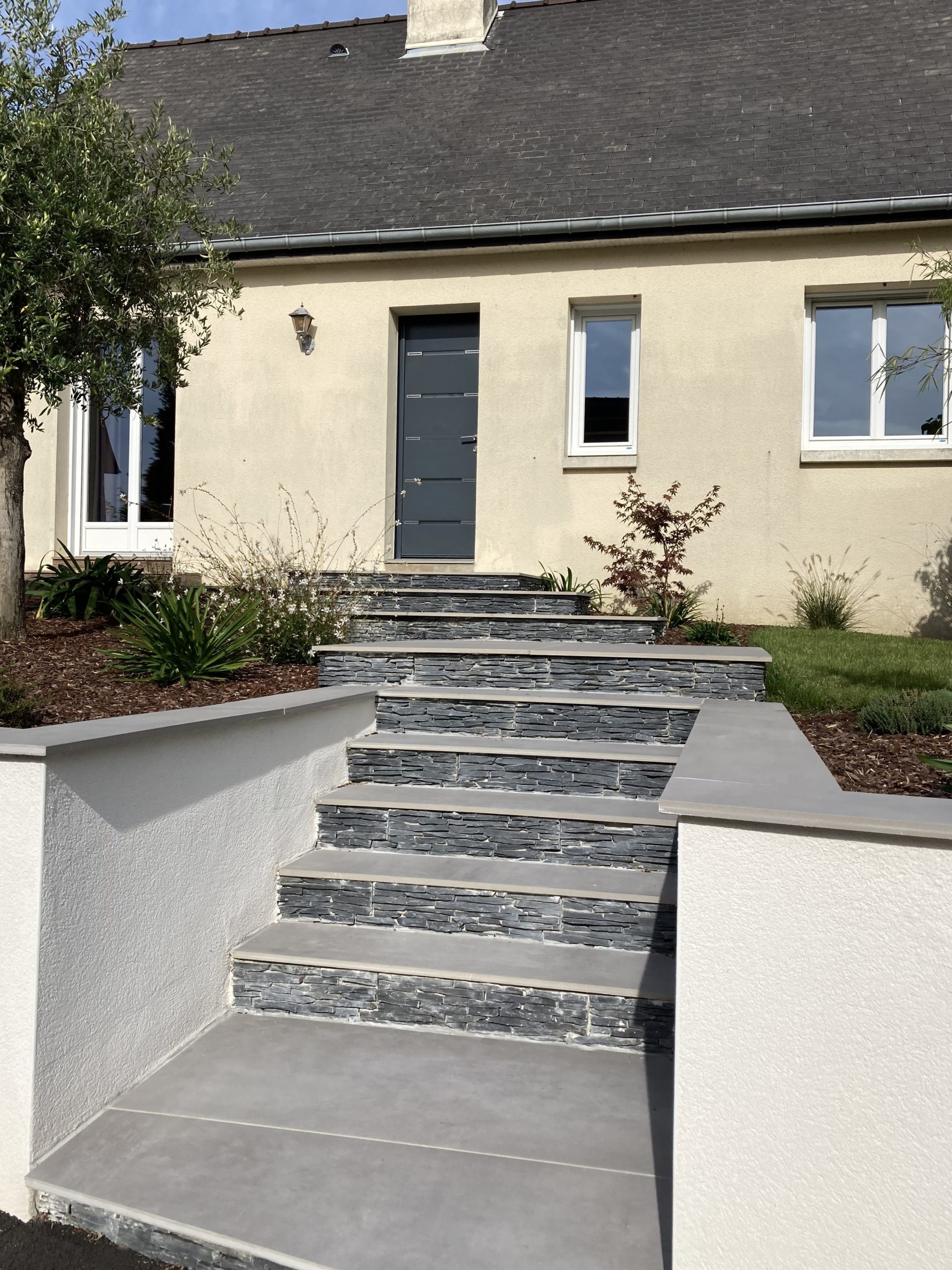 Escalier extérieur en grès cérame aménagé pour accéder à l’entrée de la maison.